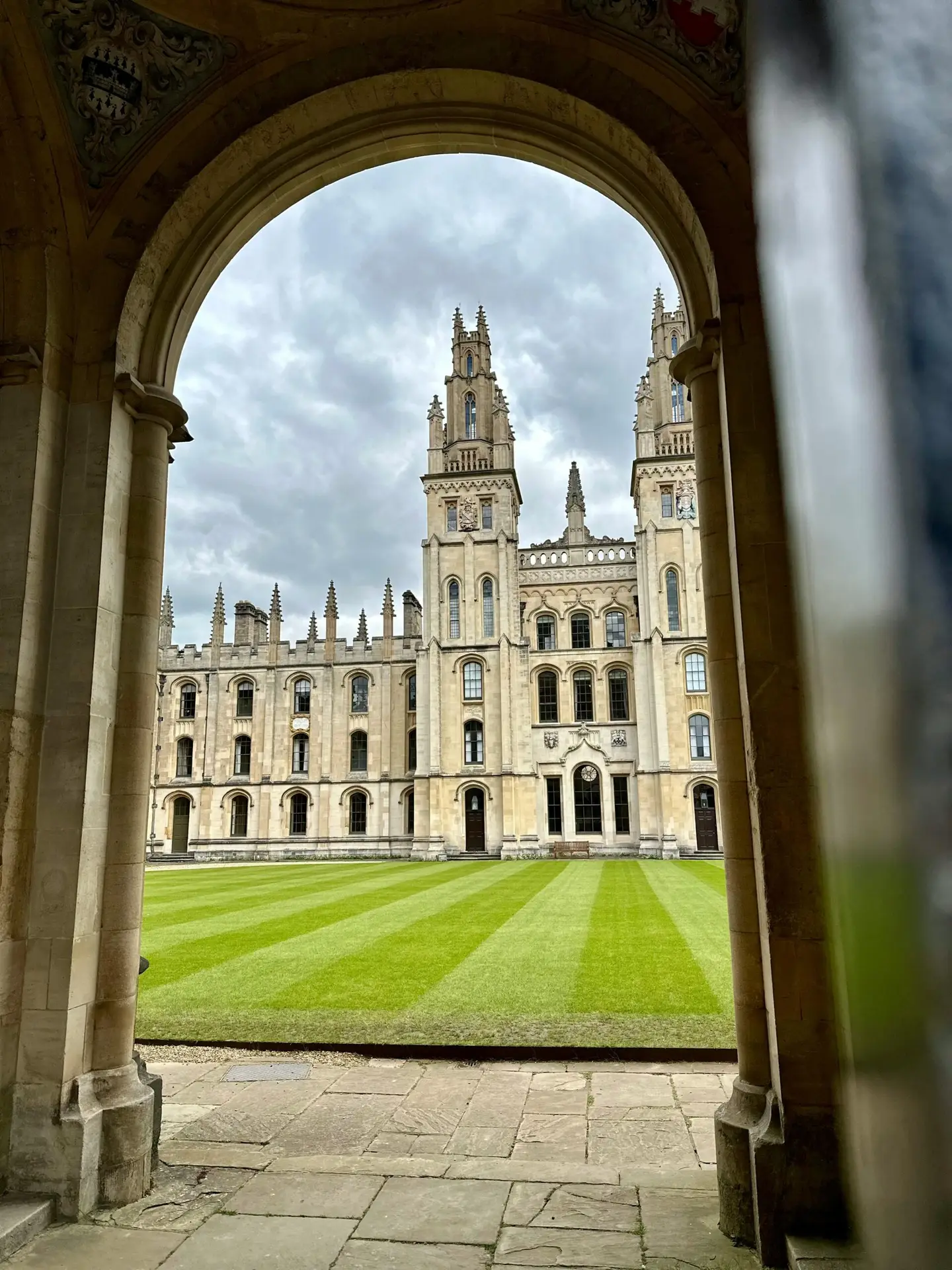 View of the historic All Souls College at Oxford University framed by an archway, perfect for educational and travel themes.